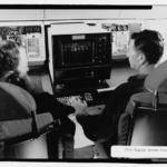 Photographic copy of photograph, 1970 (original photograph in STRATCOM Historian files, Offutt AFB, Bellevue, Nebraska). Interior view of two crew members operating the data display system in the battle staff compartment. - Offutt Air Force Base, Looking Glass Airborne Command Post, Looking Glass Aircraft, On Operational Apron covering northeast half of Project Looking Glass Historic District, Bellevue, Sarpy County, NE Photos from Survey HAER NE-9-B