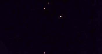 Several Orange Orbs Move Different Directions Over Ocean